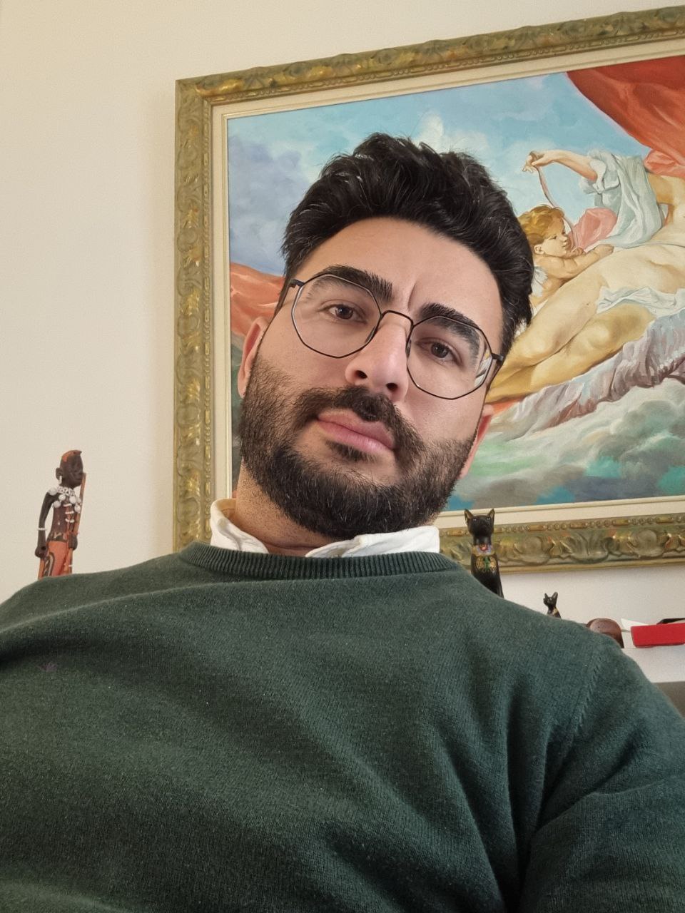 Alex in a car at night with city lights in the background.